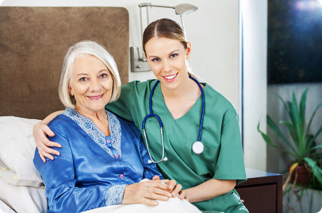 caretaker with arm around senior women at nursing home